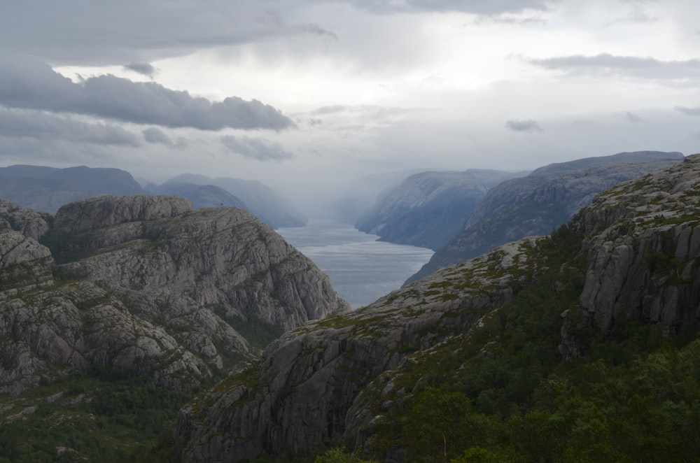 montañas y cuerpo de agua bajo el cielo blanco