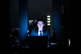 man using computer in dark room