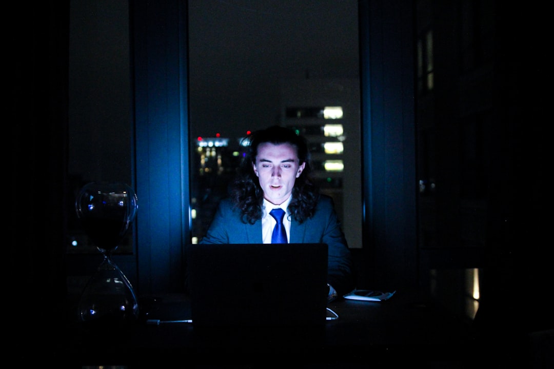 man using computer in dark room