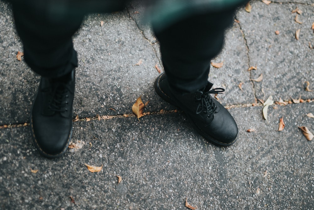 person wearing black pants and black leather boots standing