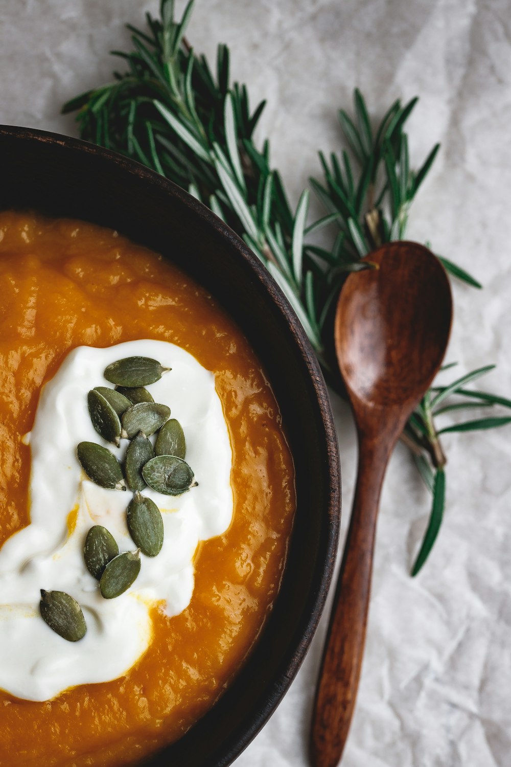 stew in round wooden bowl beside wooden spoon