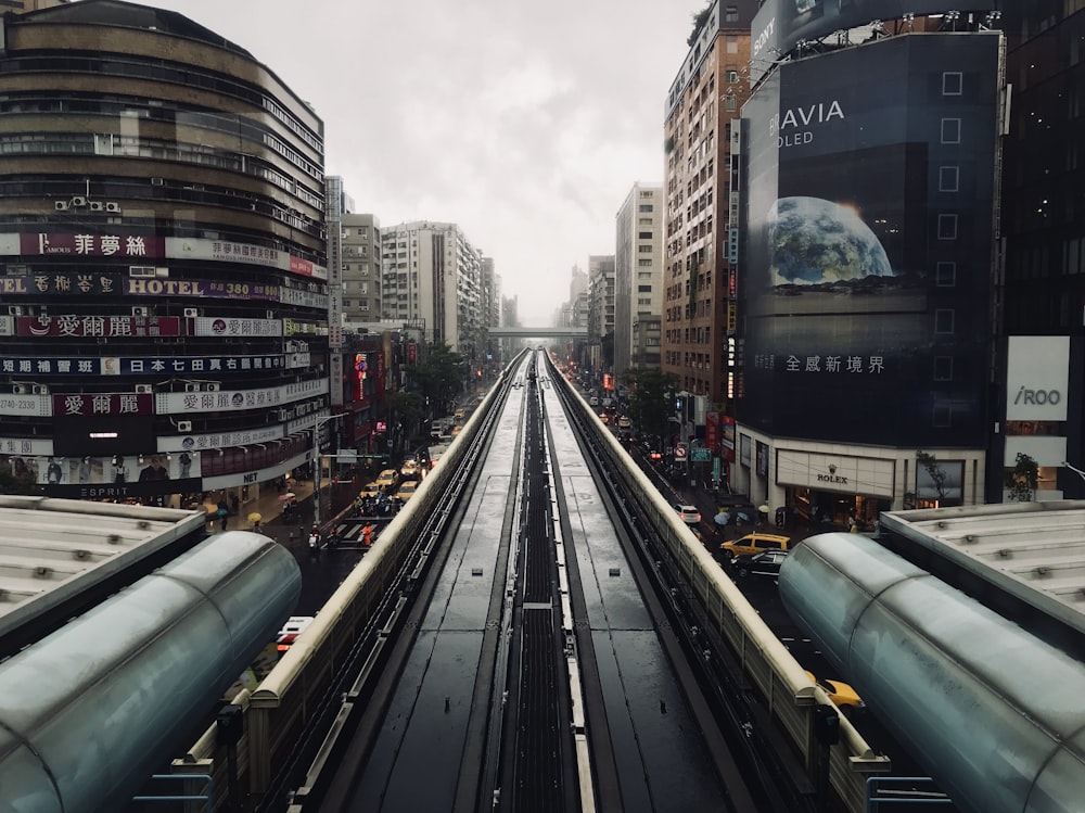 a train traveling through a city next to tall buildings