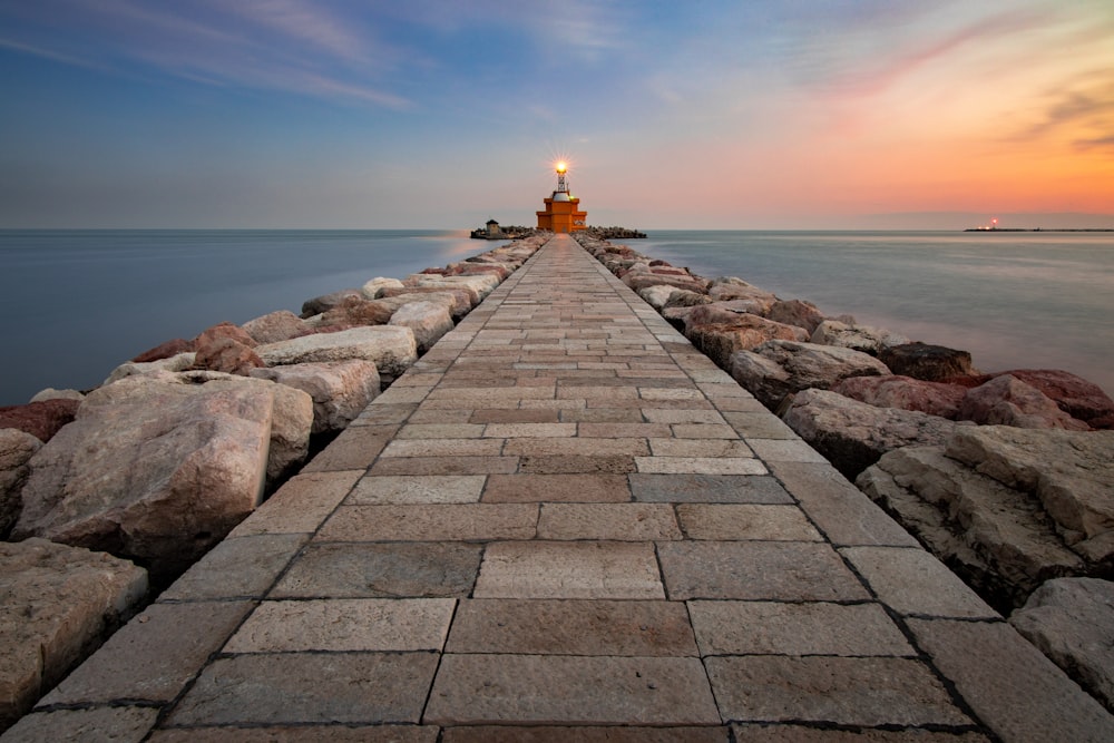 lighted lighthouse on end of pier