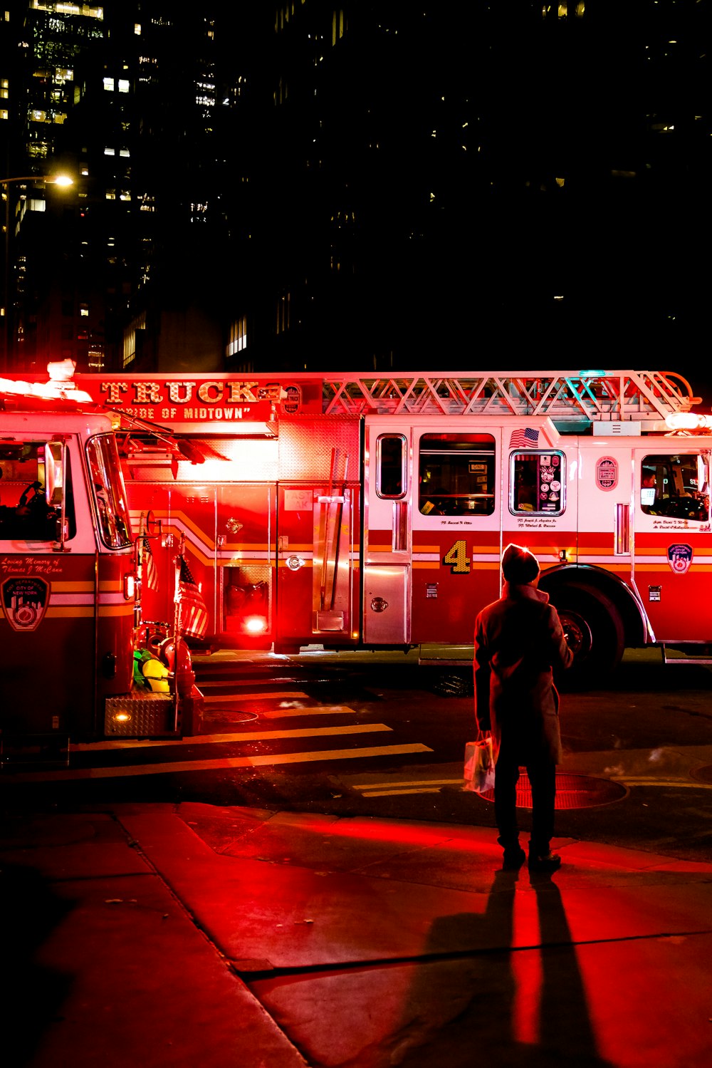 Persona parada cerca de un camión de bomberos iluminado