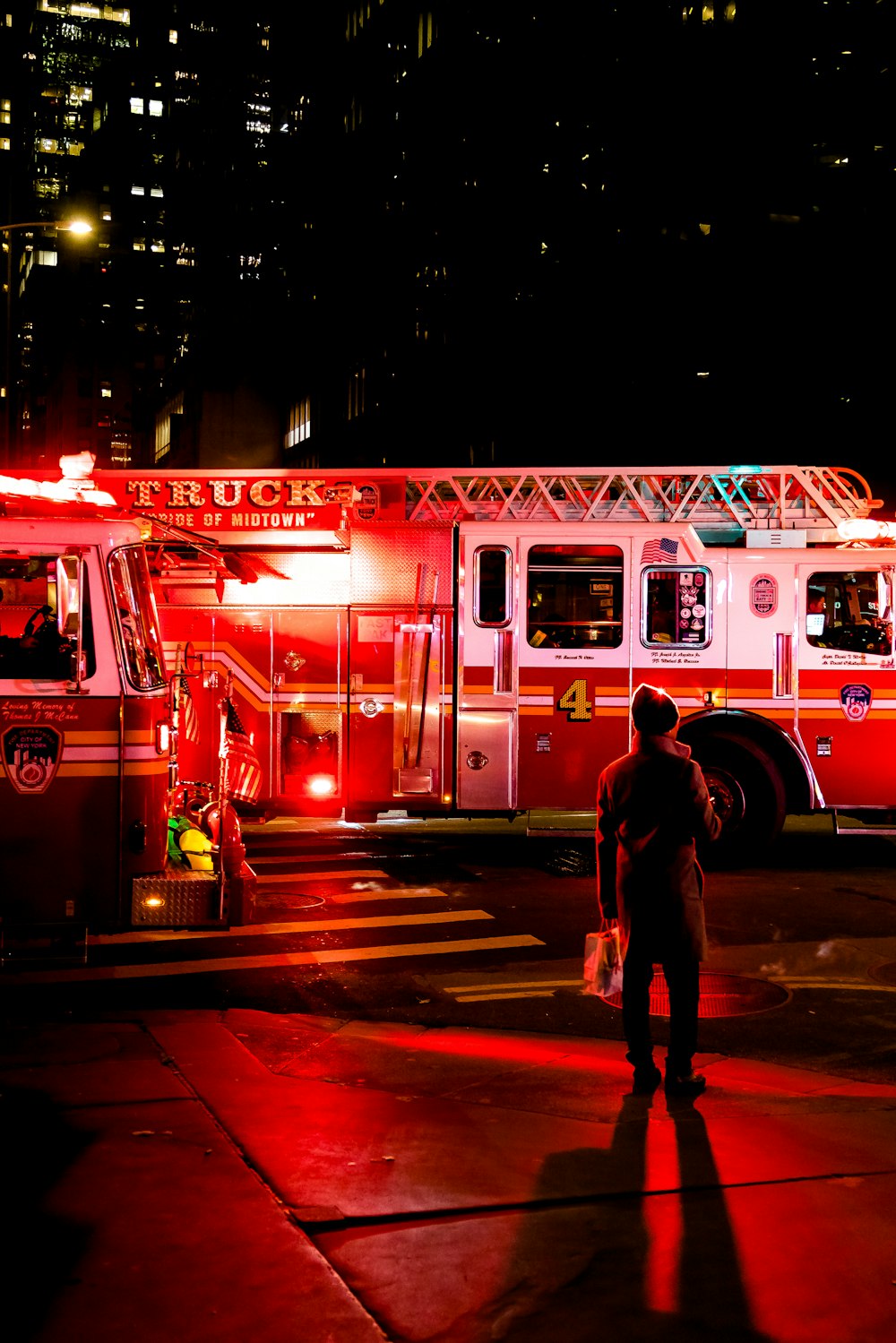 pessoa em pé perto de caminhão de bombeiros iluminado