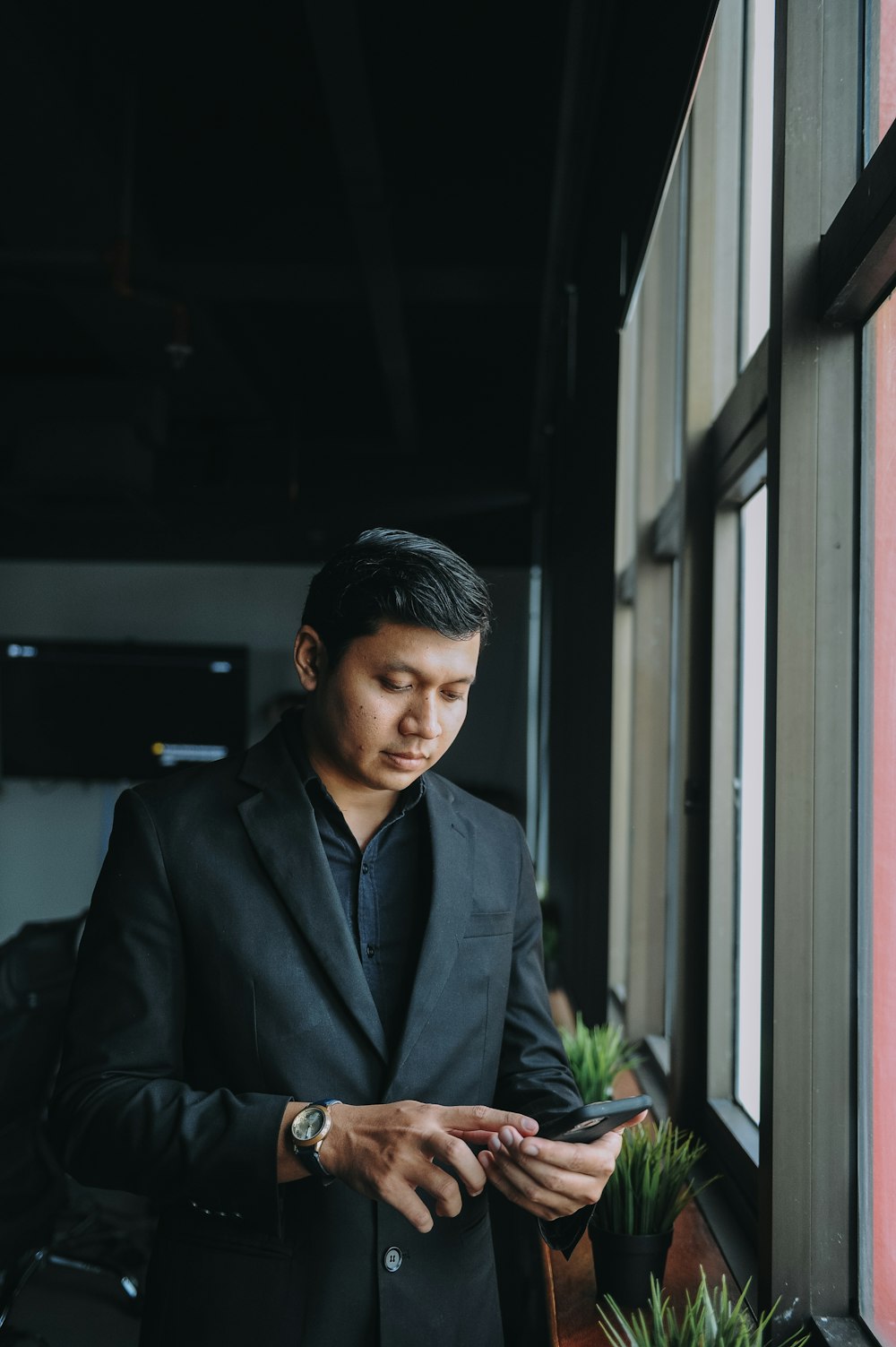 a man in a suit looking at his cell phone