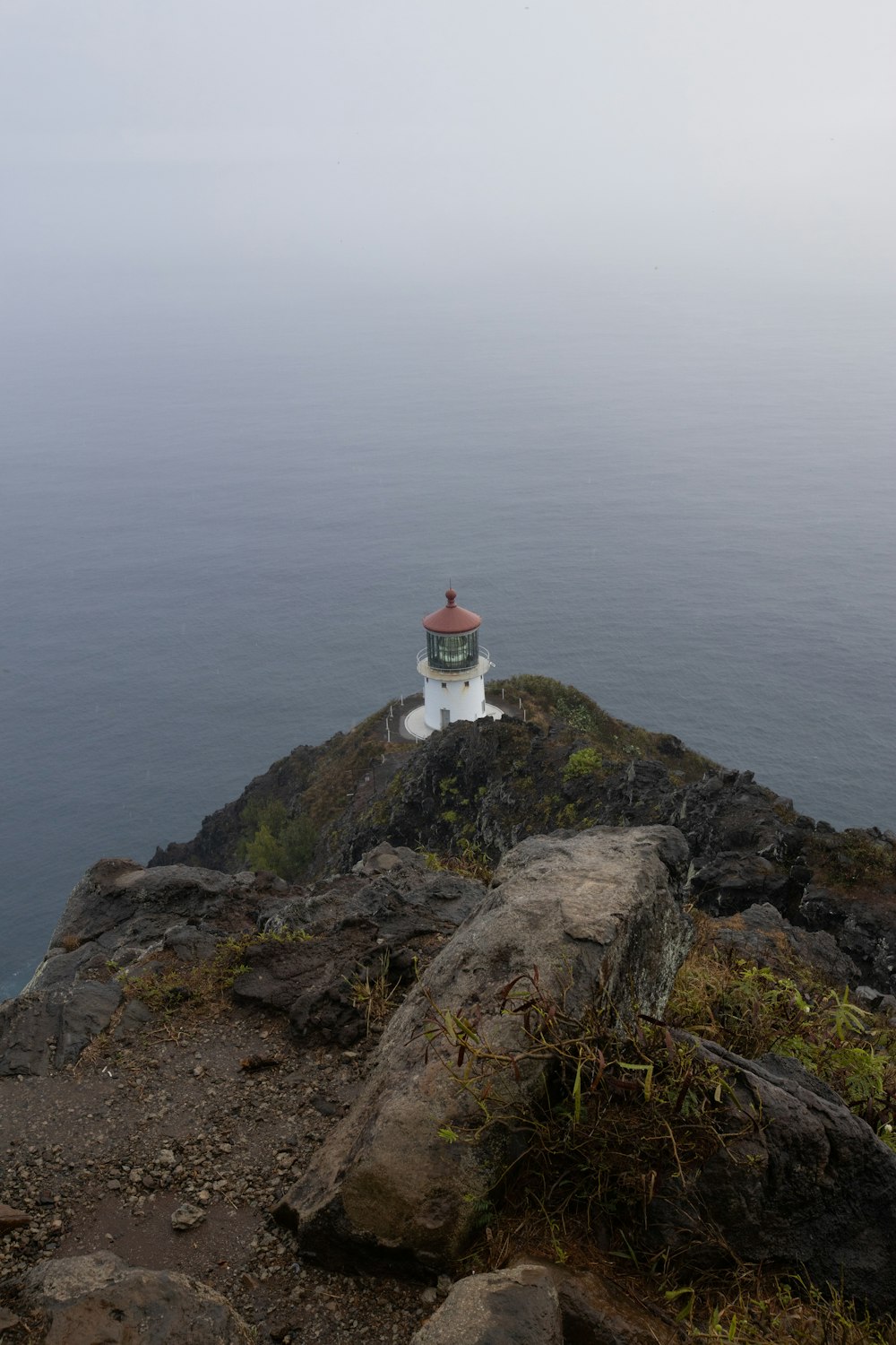 lighthouse on rocky mountain island during day