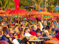 A group of friends enjoying a lively Caribbean beach party with colorful decorations.
