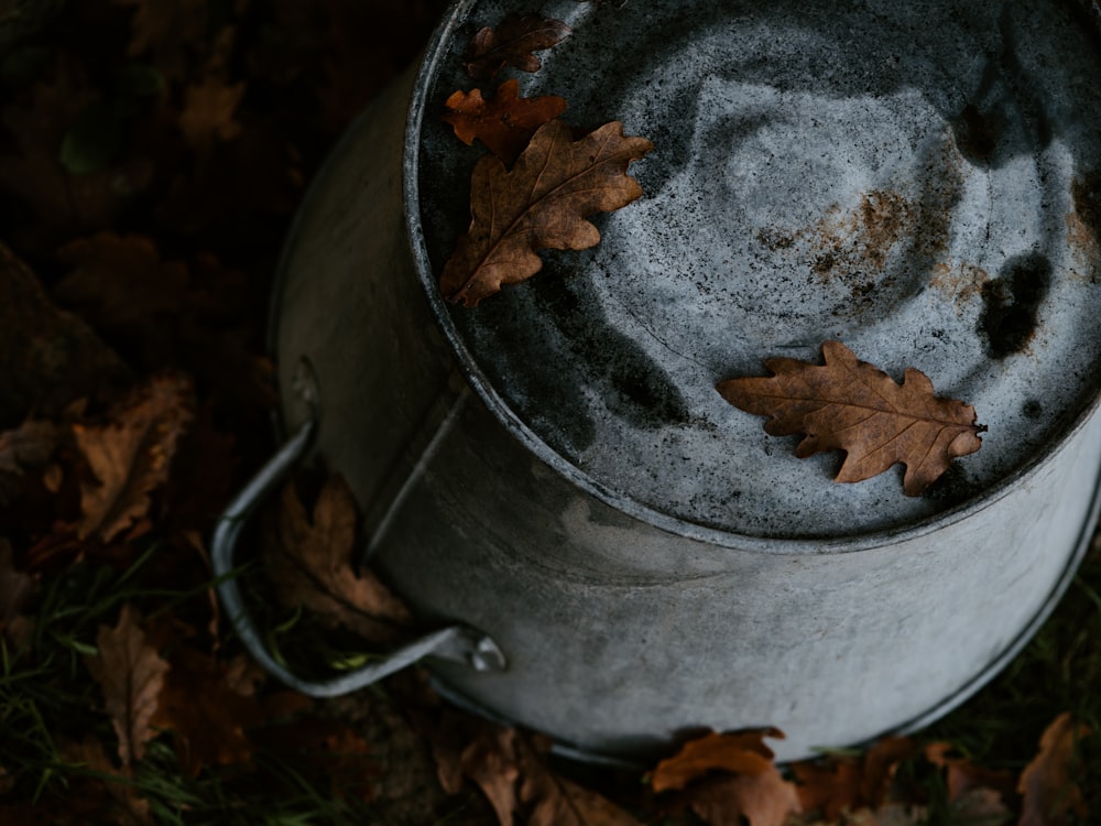 upside down gray metal pot on ground