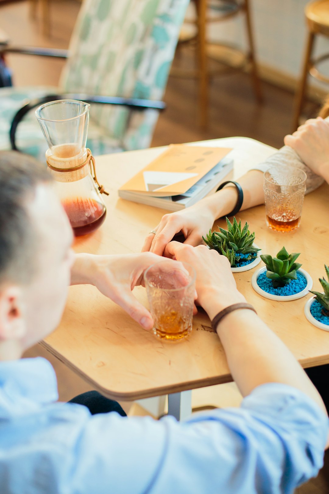 two persons sitting beside table with plants and drinks