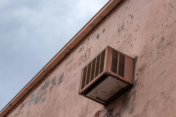 gray window-type AC unit during daytime
