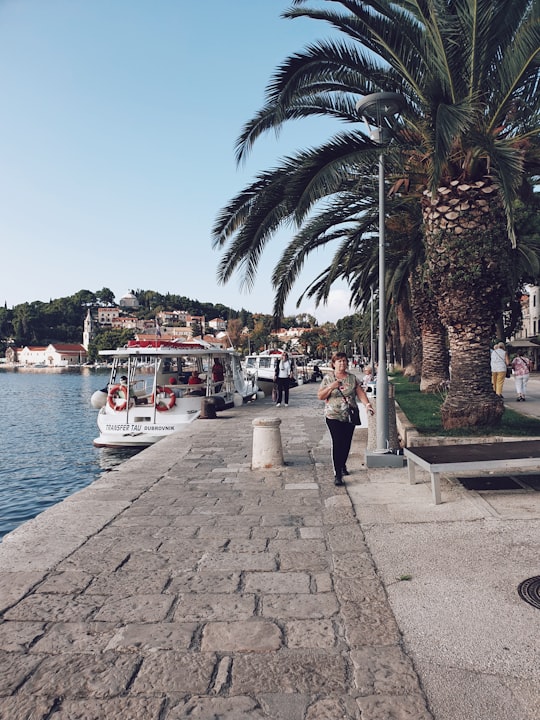 woman walking past parked boat in Cavtat Croatia