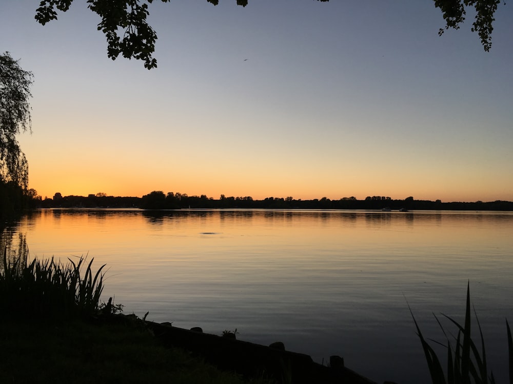 a body of water with a sunset in the background