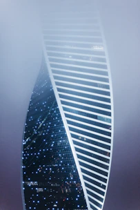 a very tall building in the middle of a foggy sky