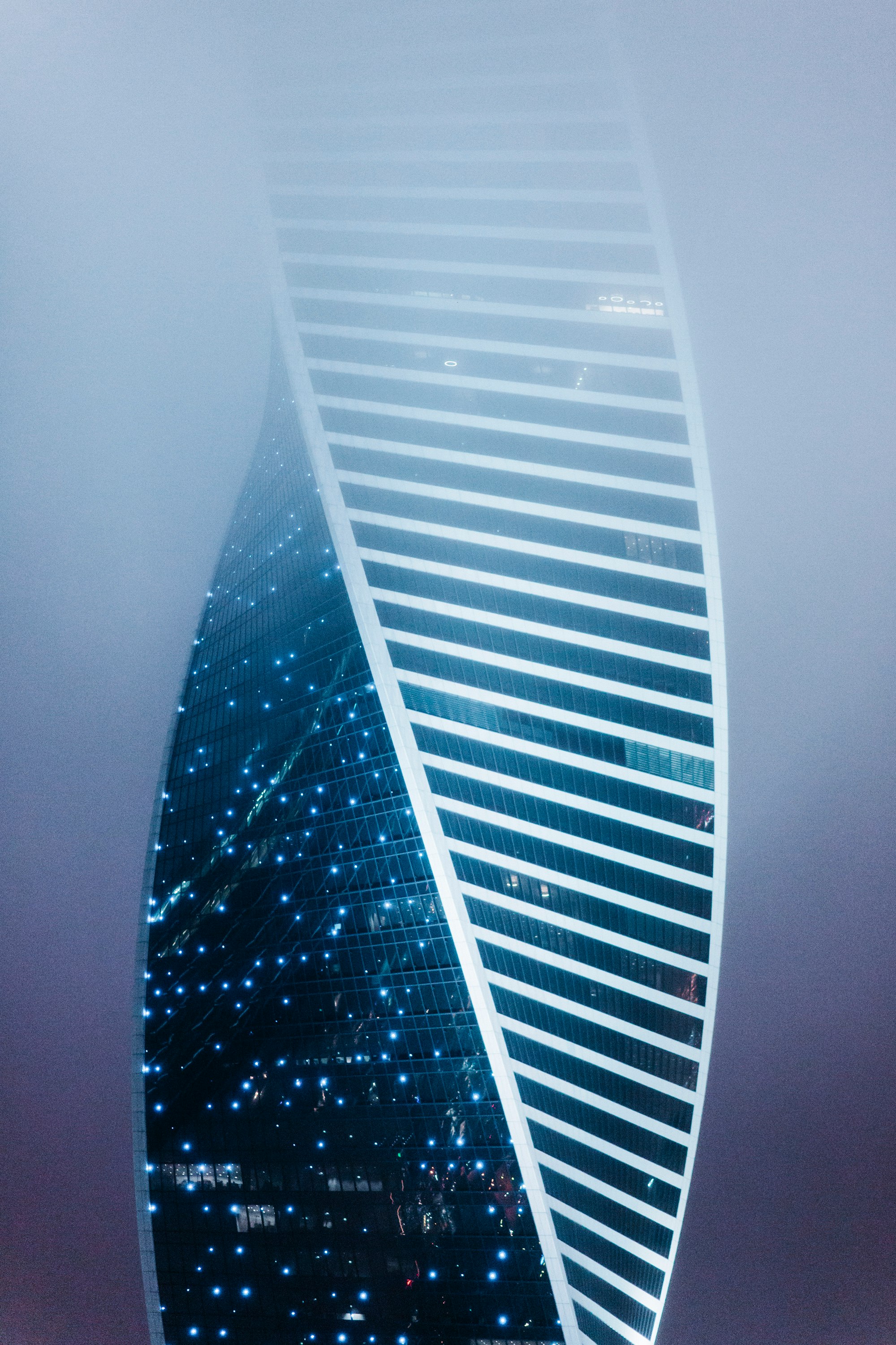 a very tall building in the middle of a foggy sky