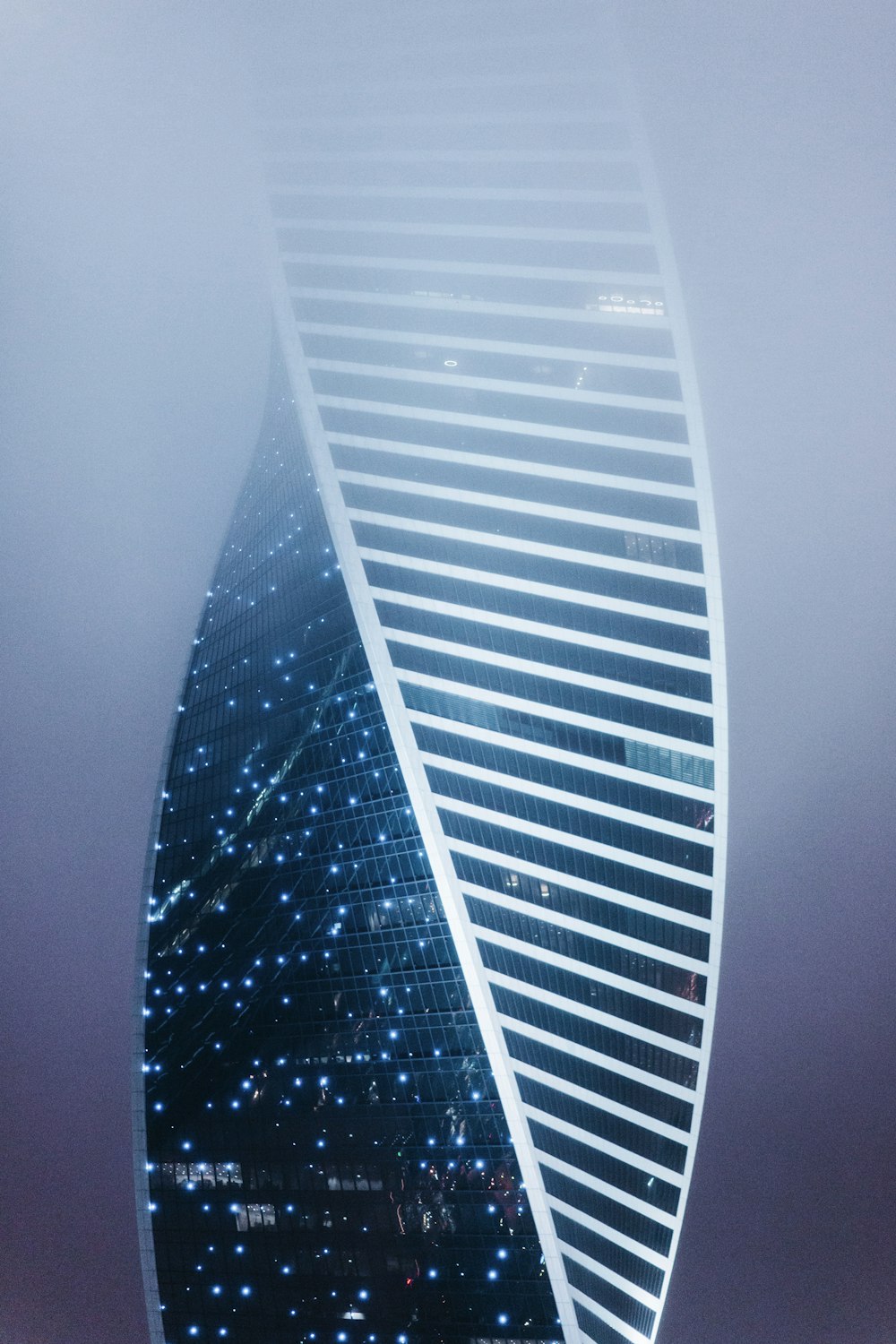 a very tall building in the middle of a foggy sky