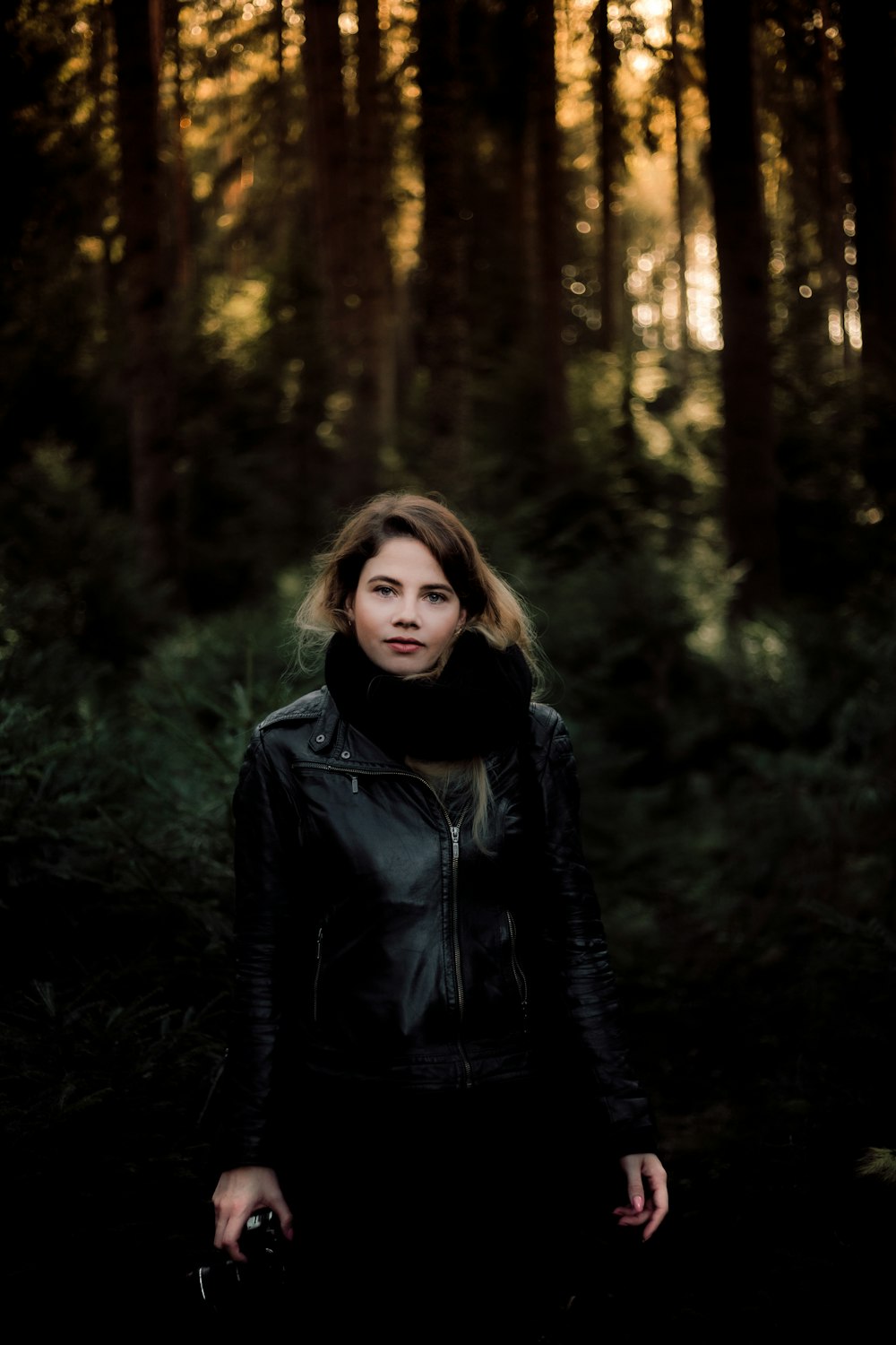 woman standing surrounded with trees during daytime