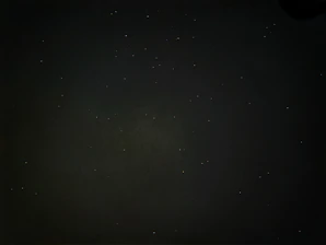 A cinematic black background with subtle glowing stars and slow-moving particles, evoking a vast story universe.