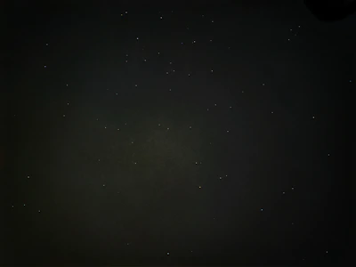 A cinematic black background with subtle glowing stars and slow-moving particles, evoking a vast story universe.