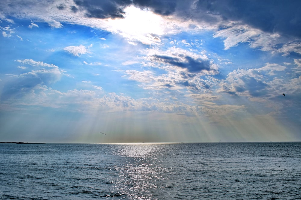 view photography of ocean under cloudy sky