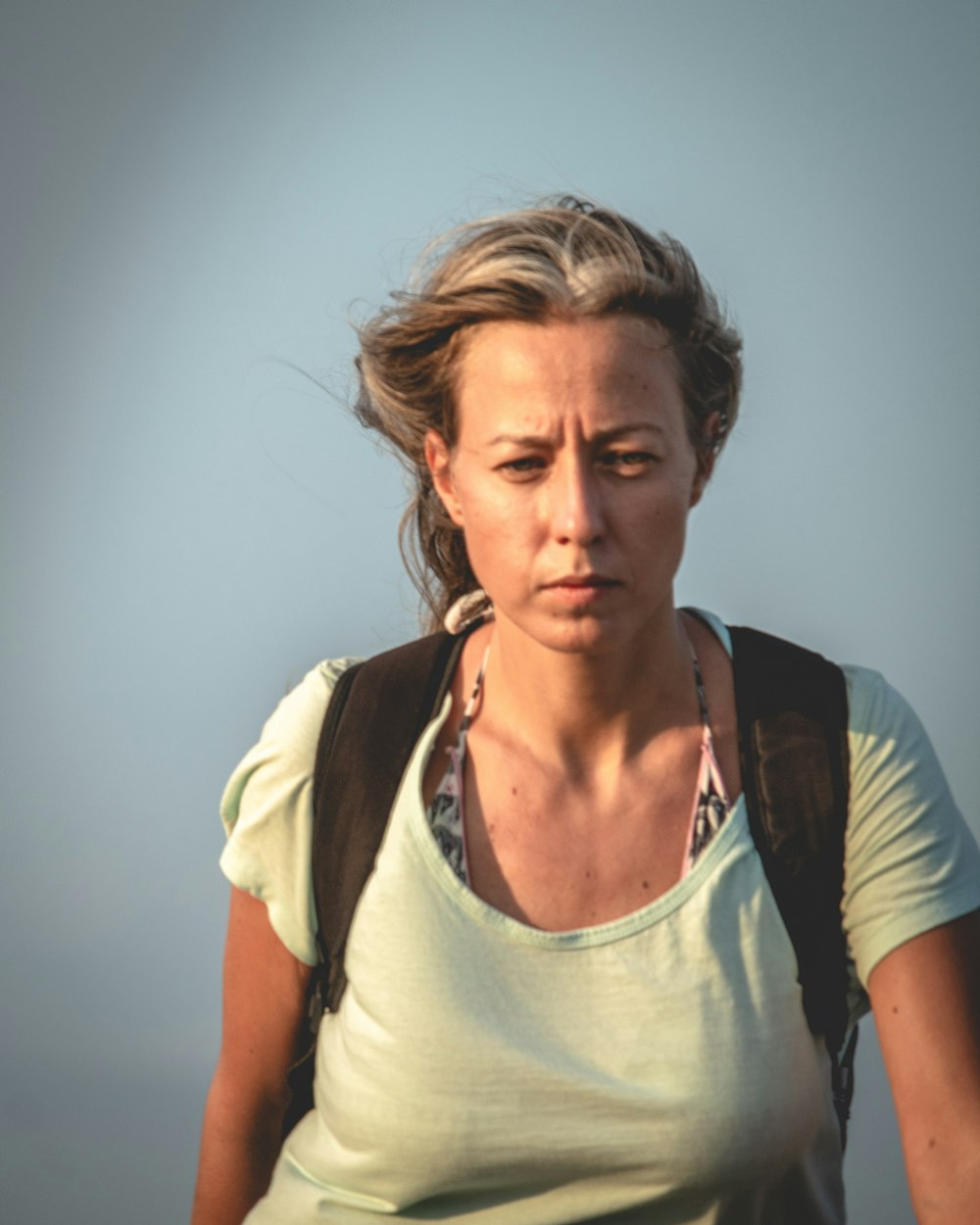 woman wearing gray scoop-neck top carrying black bag