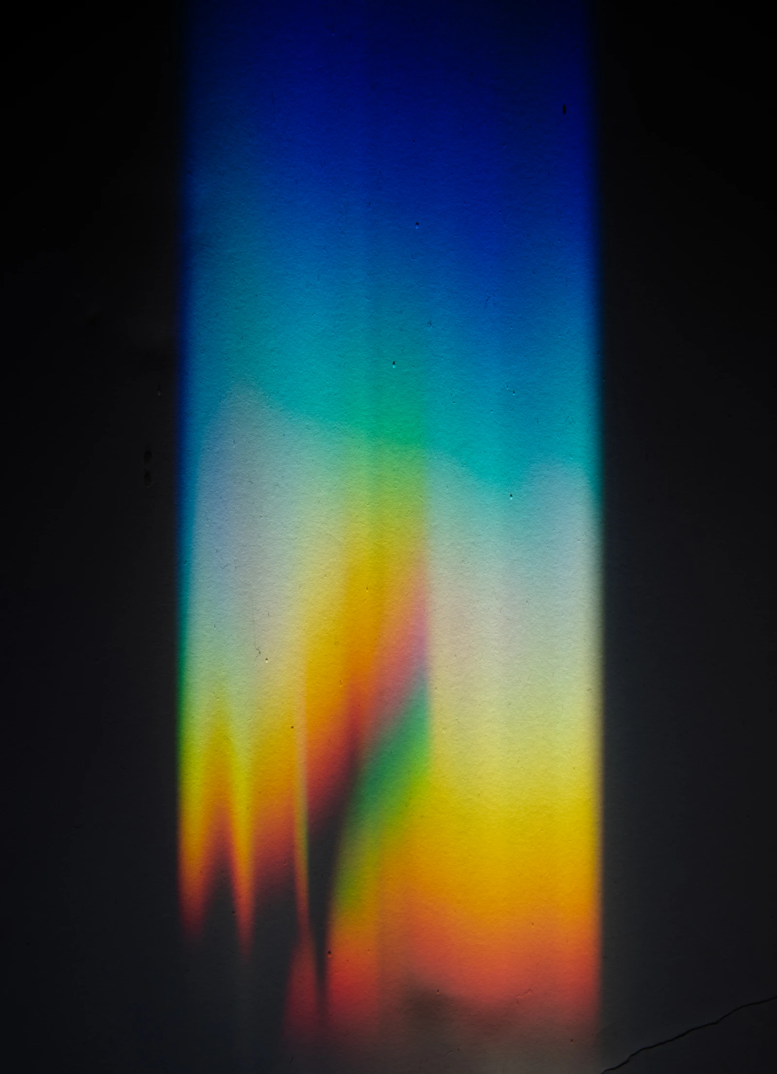 A rainbow prism spectrum on a dark surface (illustrative)