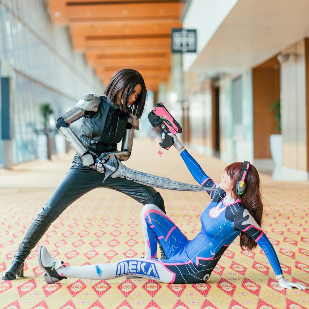 woman pointing sword to another woman