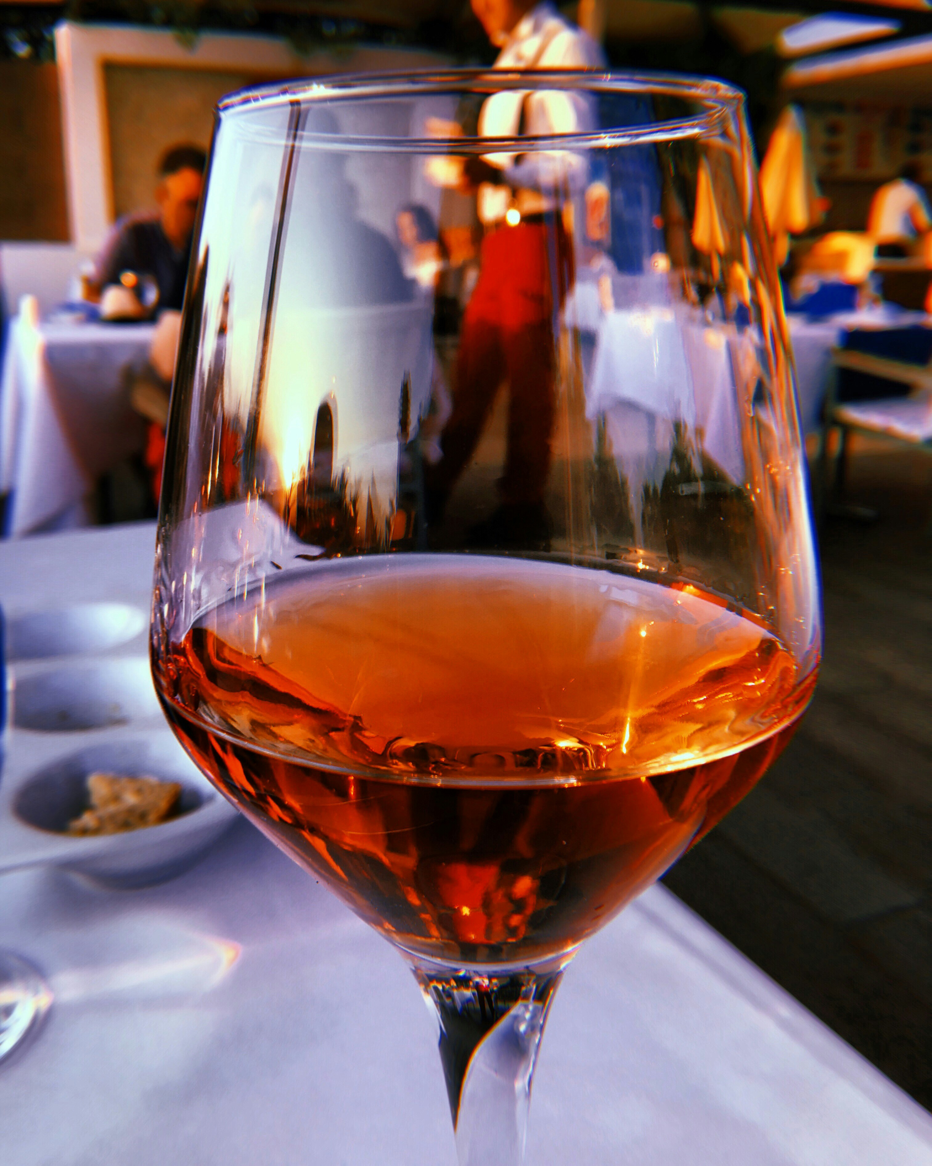 a glass of wine sitting on top of a table