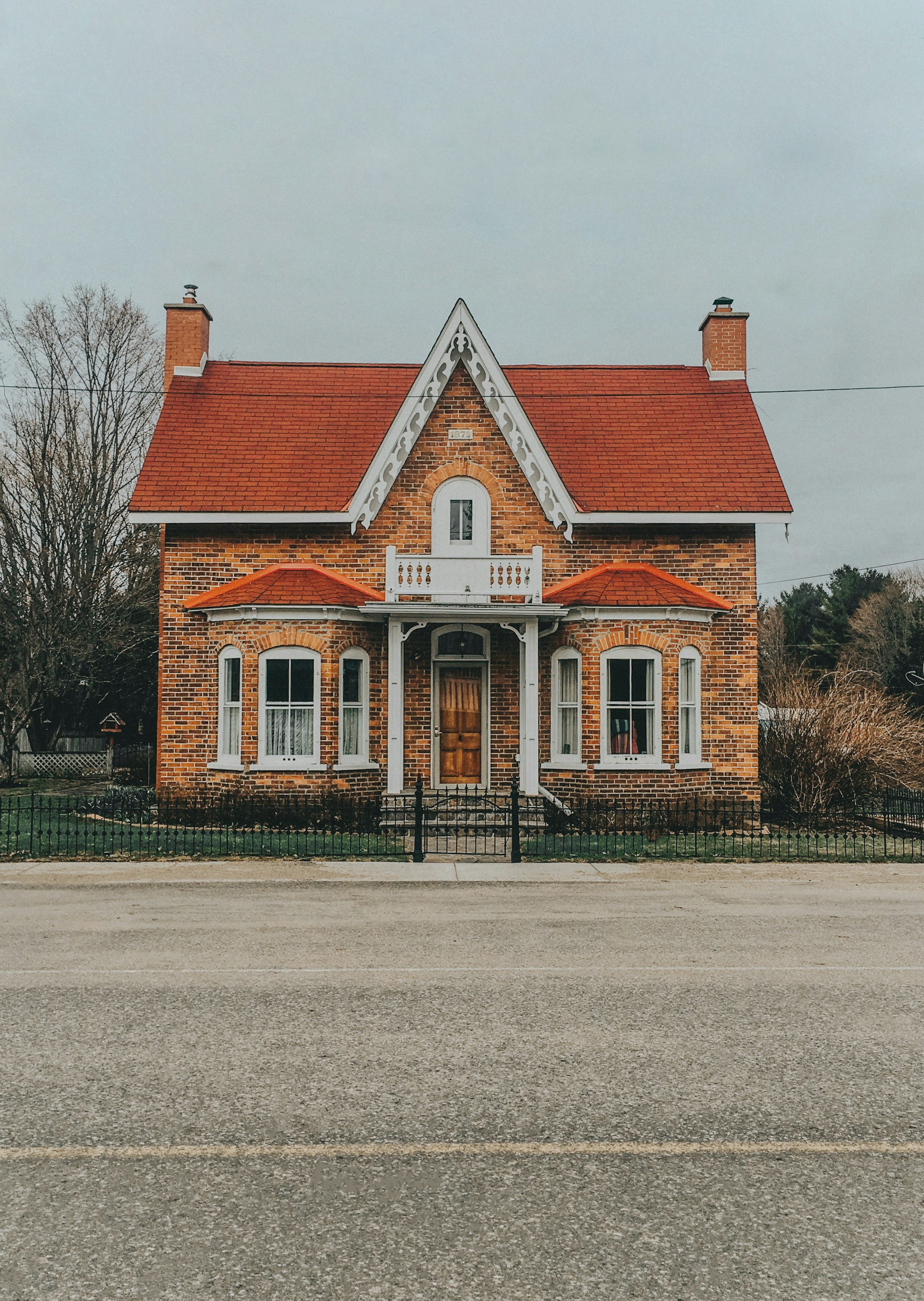 a small brick house with a red roof