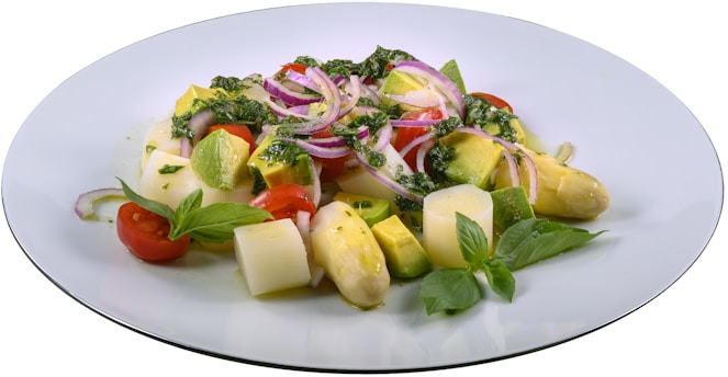 A colorful plate of keto-friendly avocado and bacon salad with cherry tomatoes and fresh herbs.