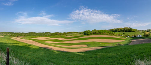 A panoramic view of the farm’s natural landscape with rolling fields and blue skies.