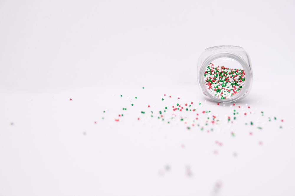 multicolored sprinkles pouring from clear jar
