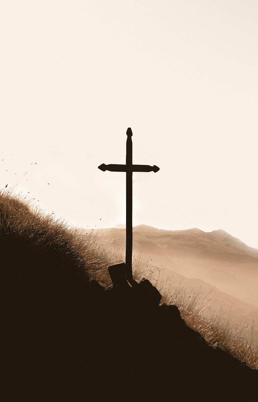 昼間の山の上の茶色の木製の十字架