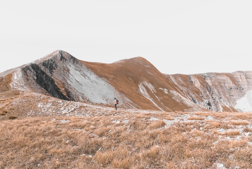 una persona in piedi sulla cima di una montagna coperta di neve