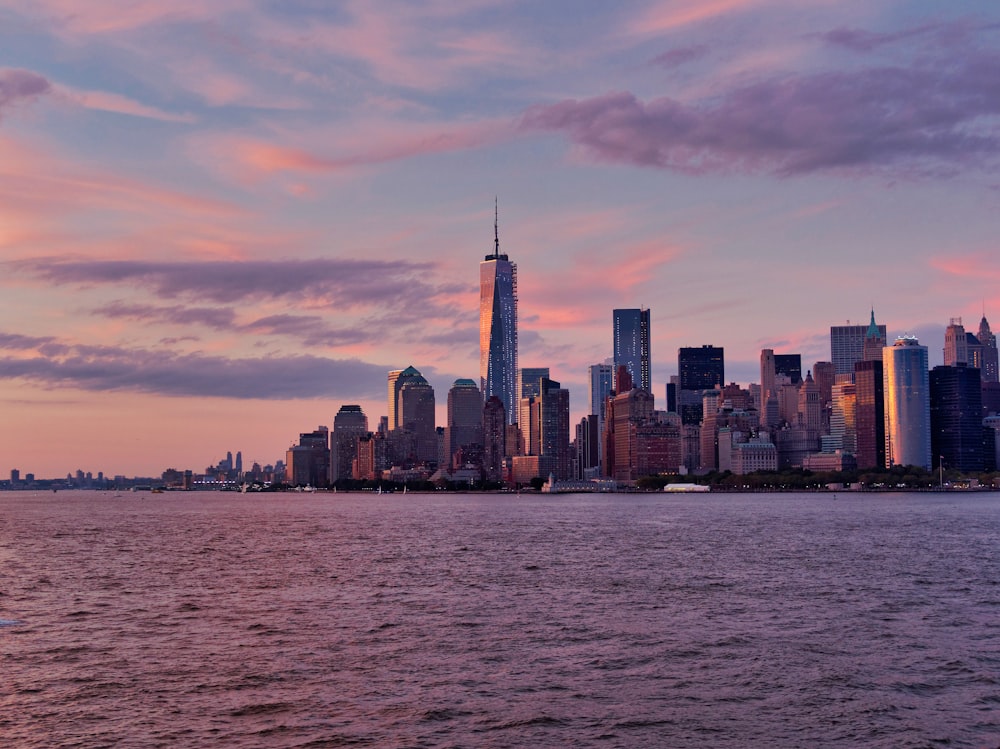 city with high-rise buildings near body of water under blue and gray sky