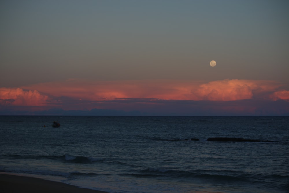 blue body of water under orange sky