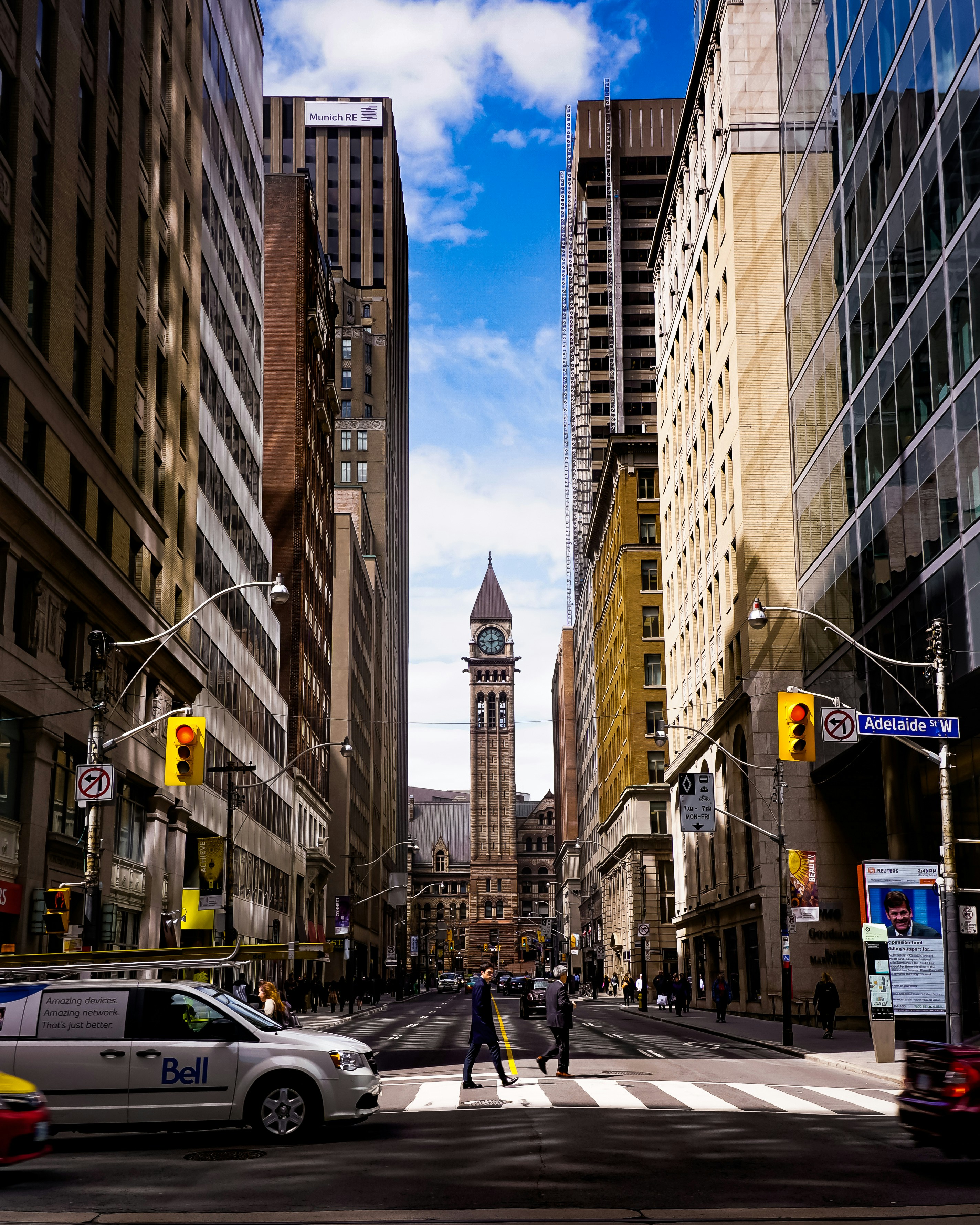 vehicles and people on road beside buildings