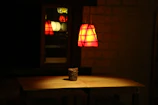 A cozy corner illuminated by a warm, moon-shaped lamp on a wooden table.