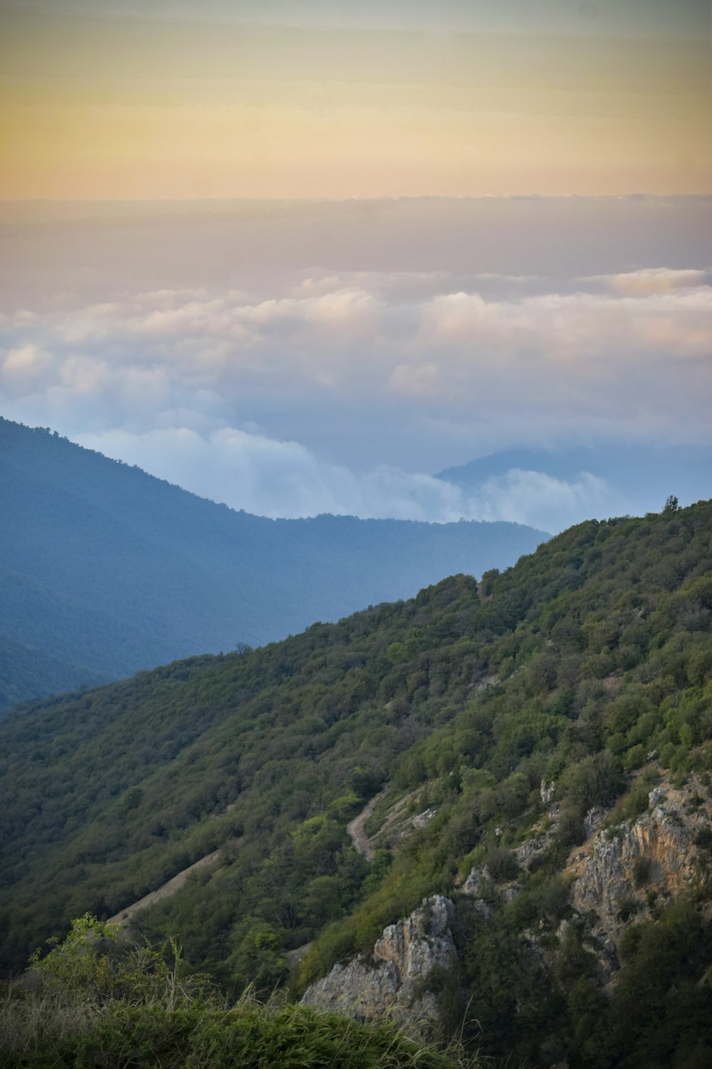 a view of a mountain with low lying clouds