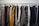 A clothing rack filled with a variety of garments, including shirts, jackets, and blazers in different colors and patterns. The assortment displays a diverse selection of fabrics and designs, indicating a collection of formal and casual wear.