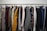 A well-organized men's clothing rack showcasing various shirts, trousers, and accessories.
