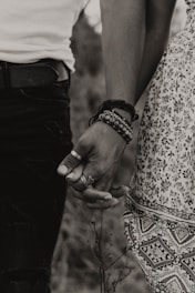 gray-scale photo of woman and man holding hands