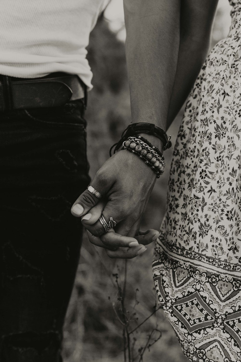 gray-scale photo of woman and man holding hands