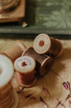 Close-up of colorful textile threads and vintage buttons arranged artistically on a wooden table.