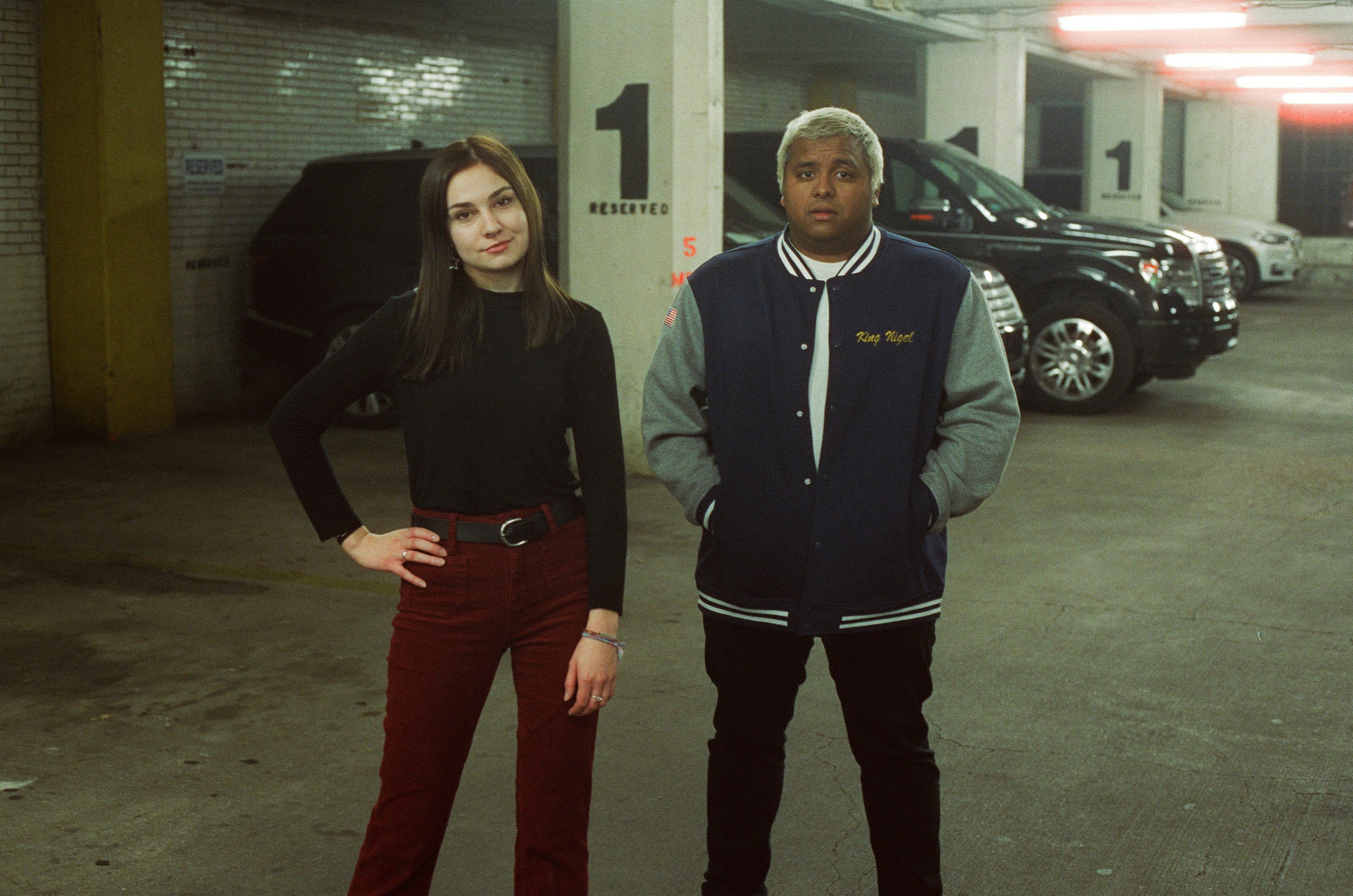 woman and man standing near parked cars at the indoor parking lot