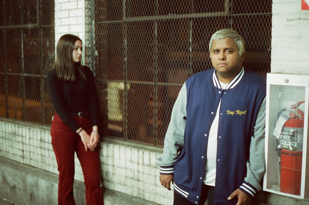 Mujer y hombre de pie junto a la pared