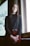 woman standing near window wearing black long-sleeved shirt during daytime