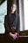 woman standing near window wearing black long-sleeved shirt during daytime