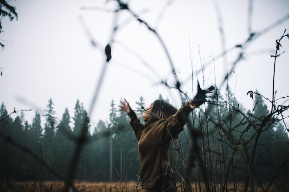 woman raising hand wide open during daytime