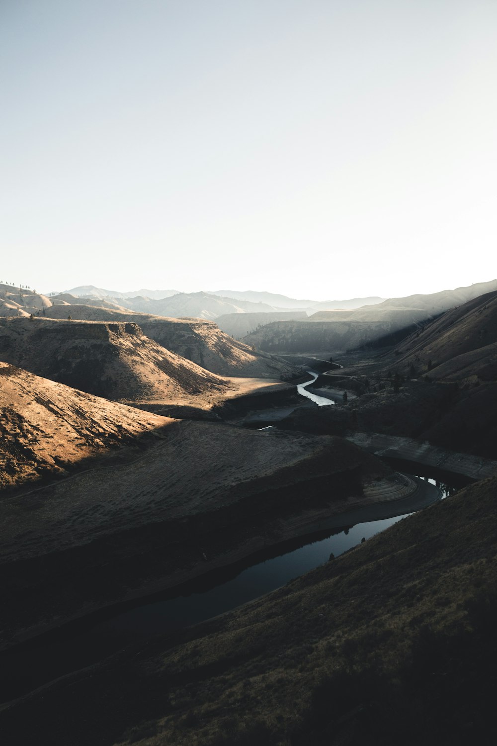 body of water between mountain during daytime